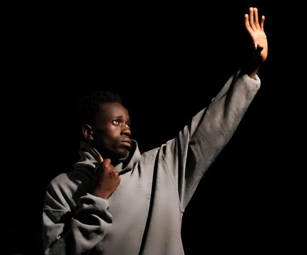 A silhouette of a man in a balanced pose against a dark background with emerald highlights.